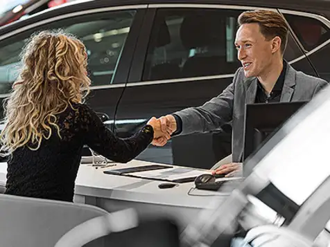 A man and women shaking hand after closing the best deal of Used minibus in Hertfordshire